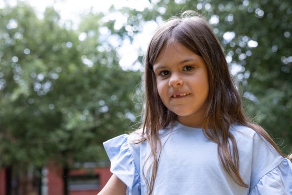 Authentisches Kinderporträt eines Mädchens im Grünen