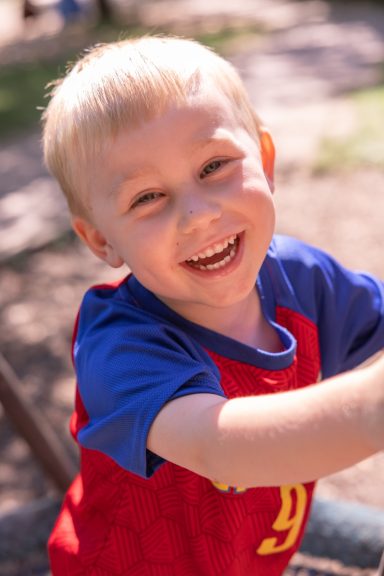 lachender Junge im blauen Shirt bei einem natürlichen Kinderporträt in Braunschweig